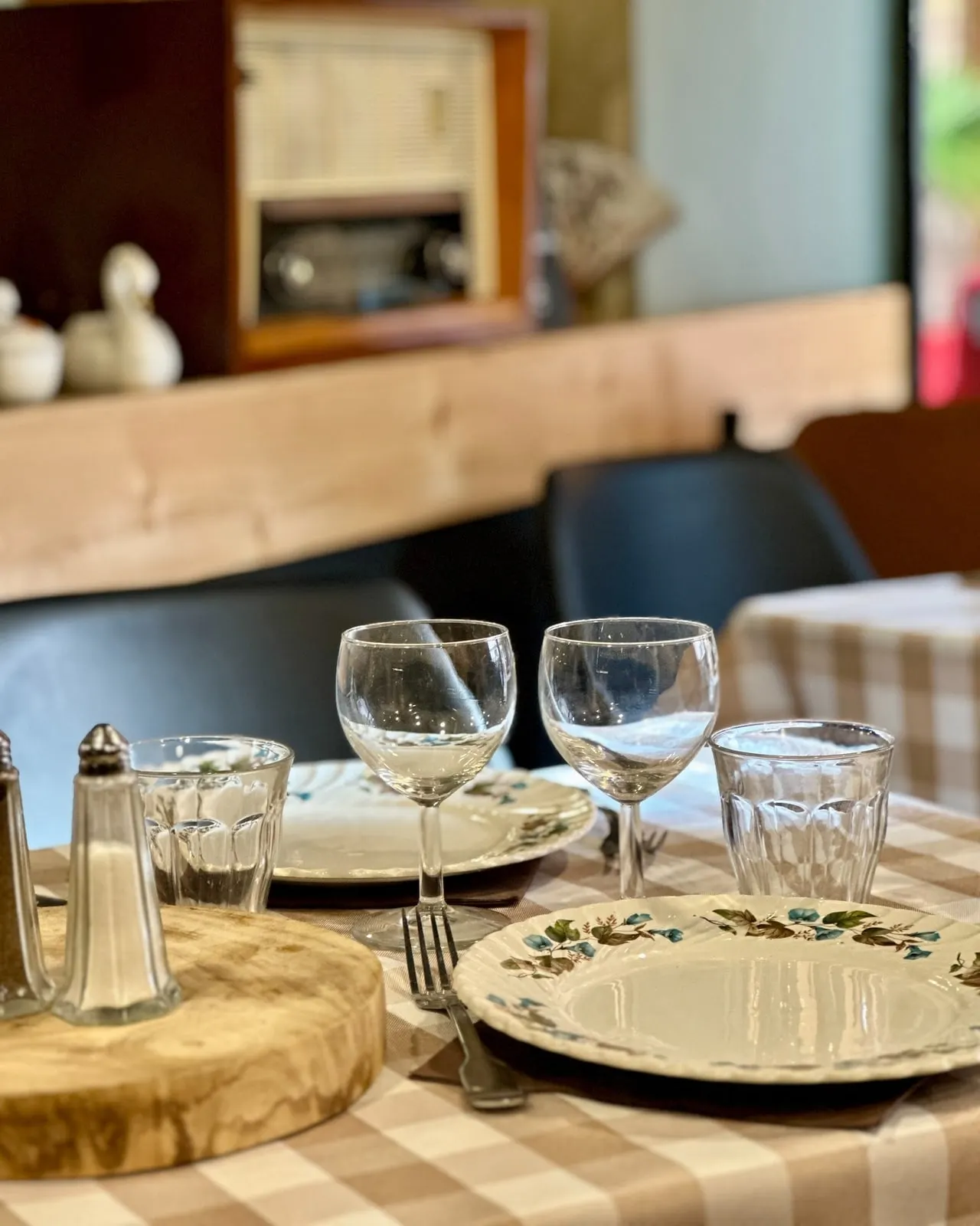 Table dressée avec nappe à carreaux et vaisselle vintage au restaurant Les Cocottes à Roanne