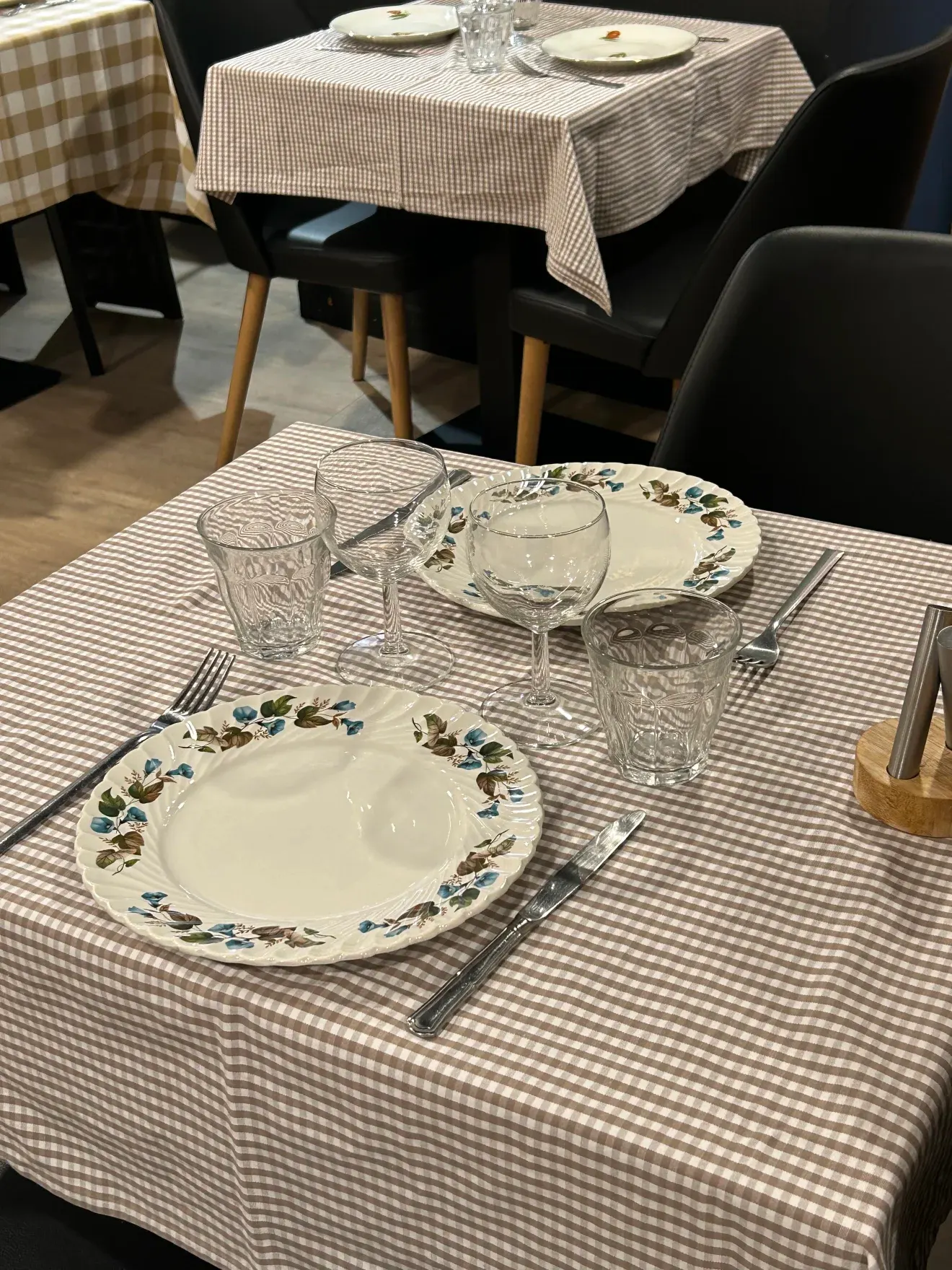 Table dressée, nappe à carreaux et assiettes fleuries aux Cocottes